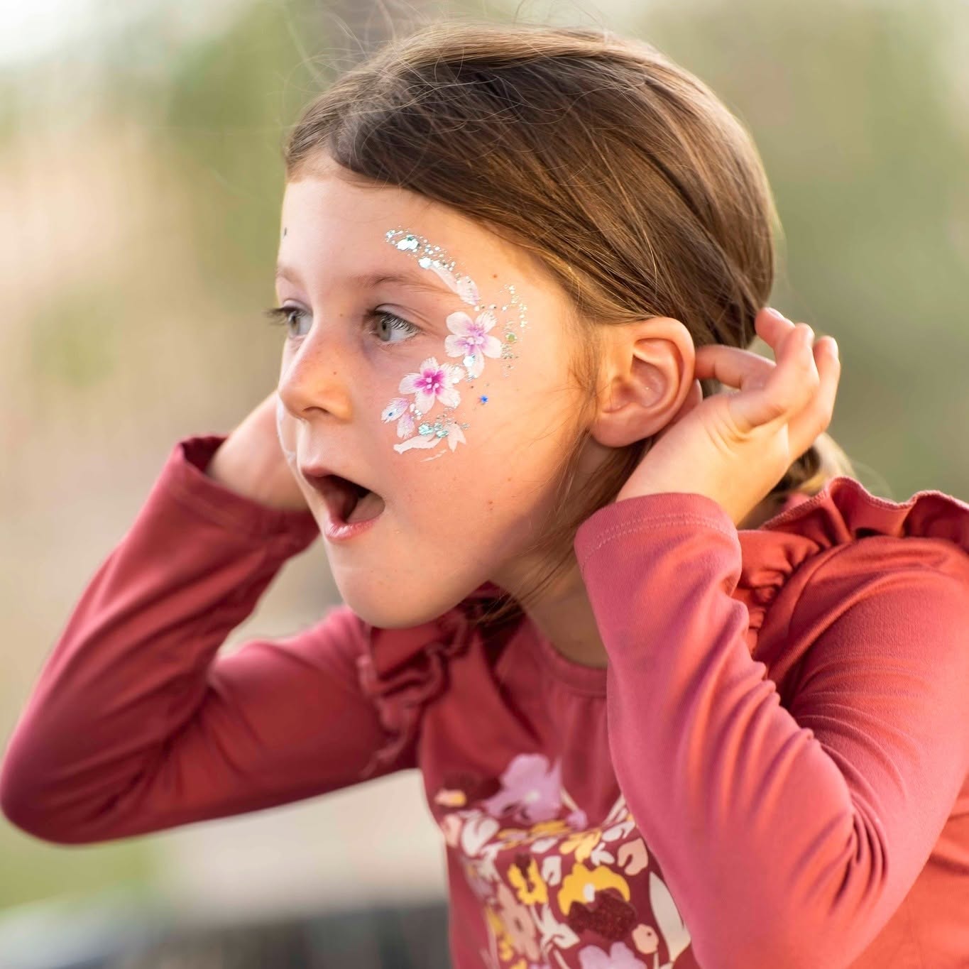 Delicate floral face paint with glitter
