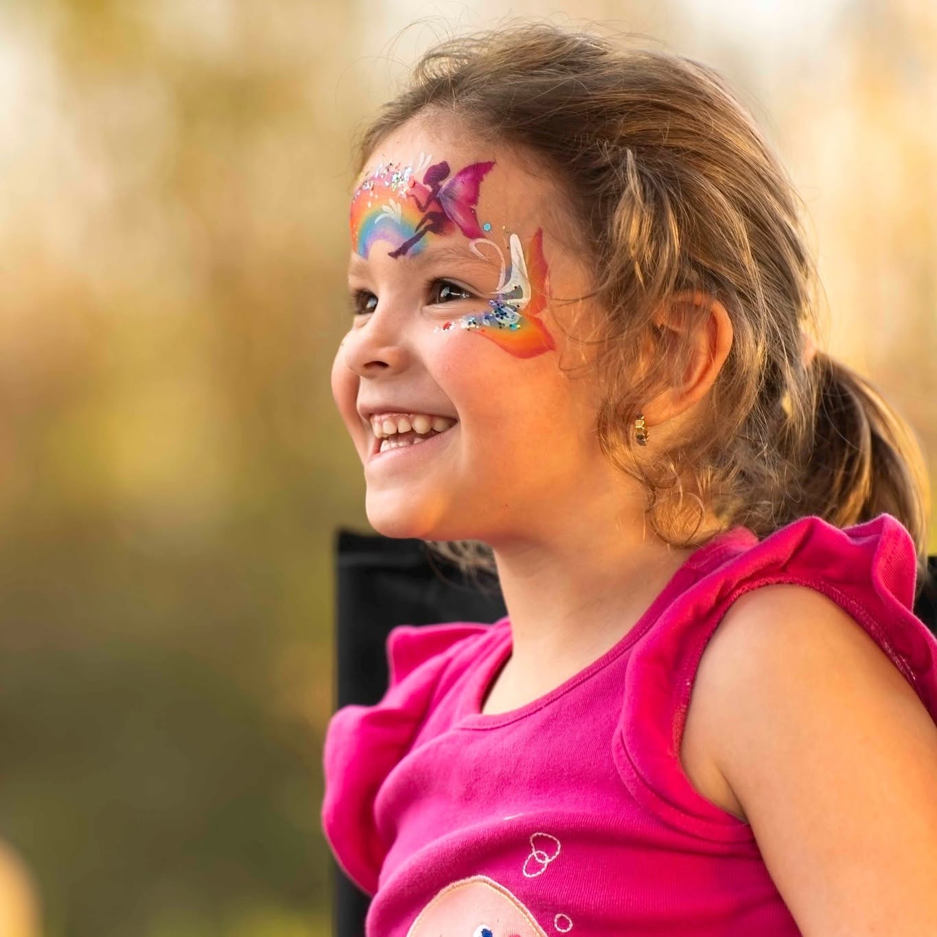 Colorful rainbow fairy face paint with glitter