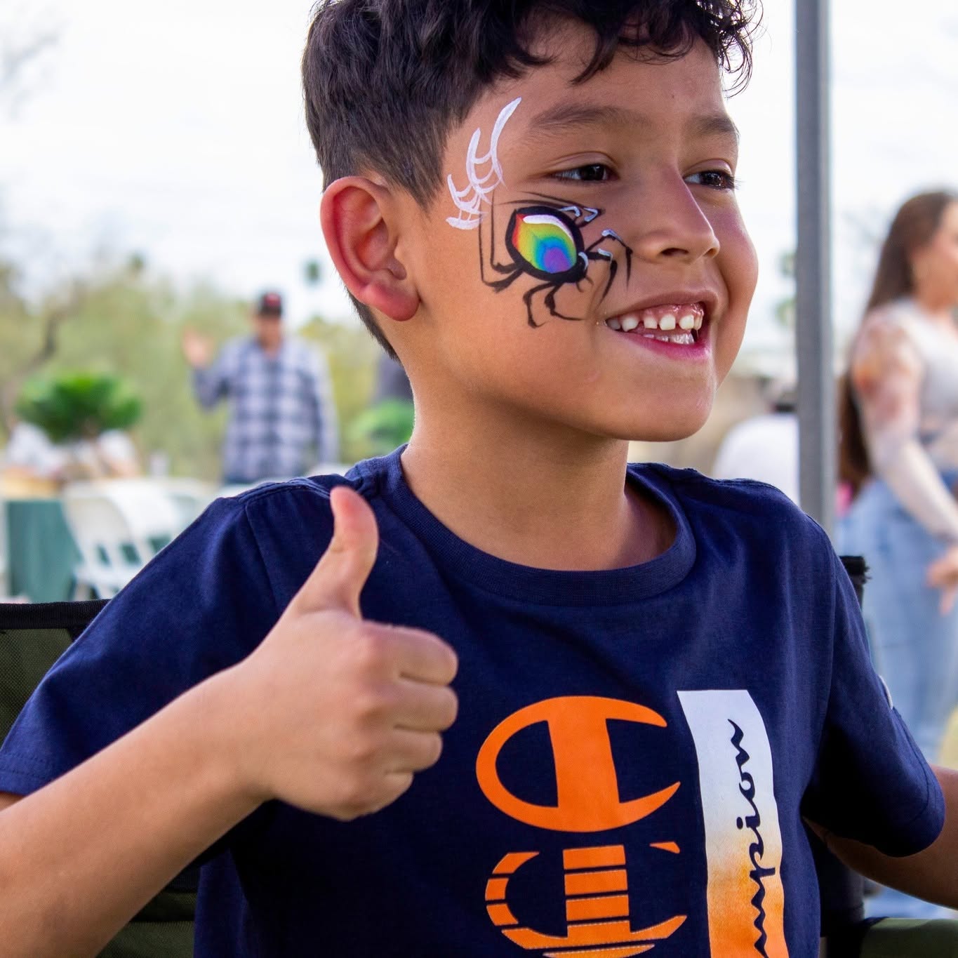 Rainbow spider face painting at a community event
