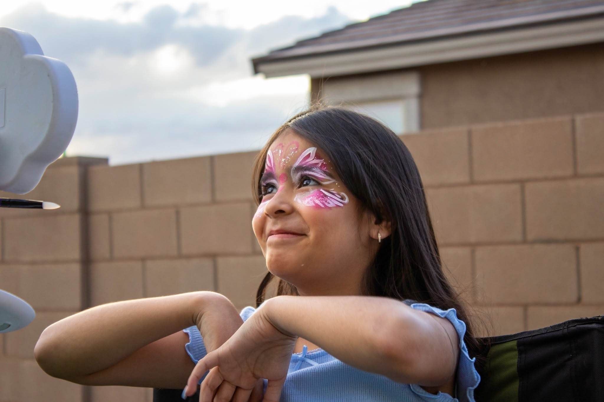 Child showing a purple butterfly face-paint design