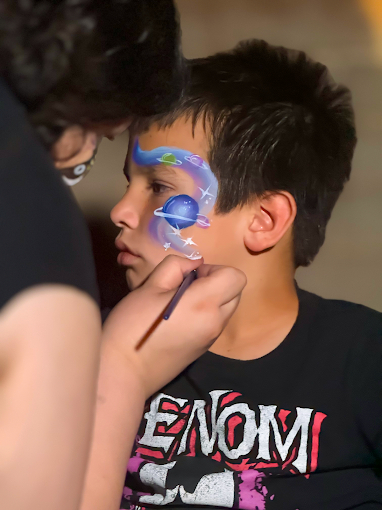 Space-themed face painting with planets and stars