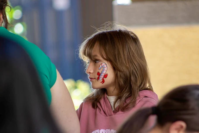 Candy cane cheek art at a Tucson Christmas event